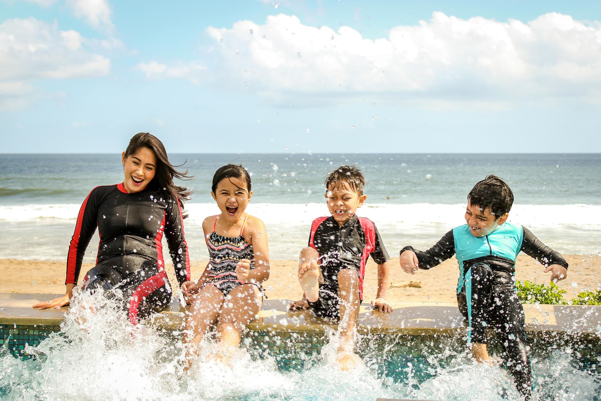 Family enjoying beach activities and splashing in the water